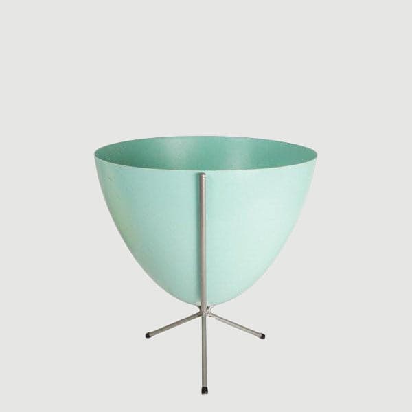 In front of white background is a turquoise planter in a short silver metal stand. The bullet planter is wide at the top and narrow at the bottom. The metal stand has three legs. 