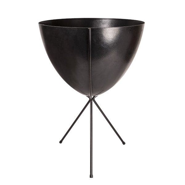 In front of white background is a black planter in a black metal stand. The bullet planter is wide at the top and narrow at the bottom. The metal stand has three legs. 