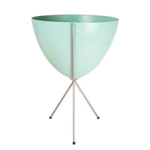 In front of white background is a turquoise planter in a silver metal stand. The bullet planter is wide at the top and narrow at the bottom. The metal stand has three legs. 