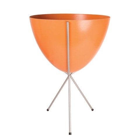 In front of white background is an orange planter in a silver metal stand. The bullet planter is wide at the top and narrow at the bottom. The metal stand has three legs. 