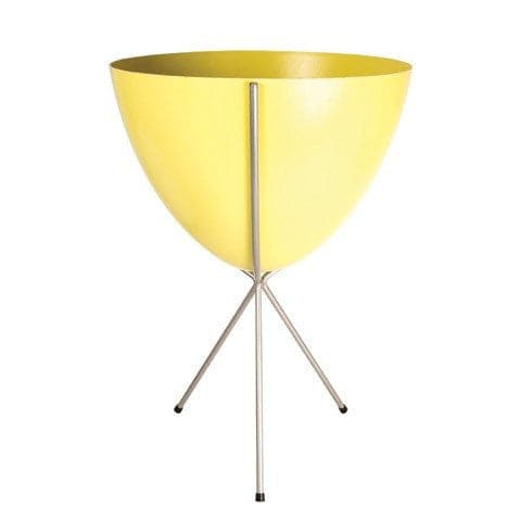 In front of white background is a yellow planter in a silver metal stand. The bullet planter is wide at the top and narrow at the bottom. The metal stand has three legs. 