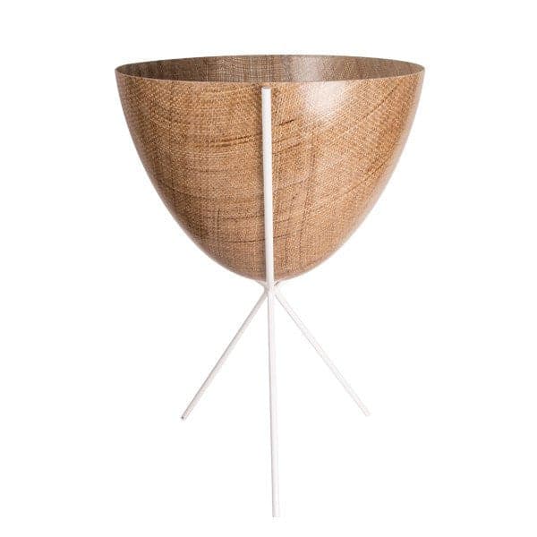 In front of white background is a wood colored planter in a white metal stand. The bullet planter is wide at the top and narrow at the bottom. The metal stand has three legs.