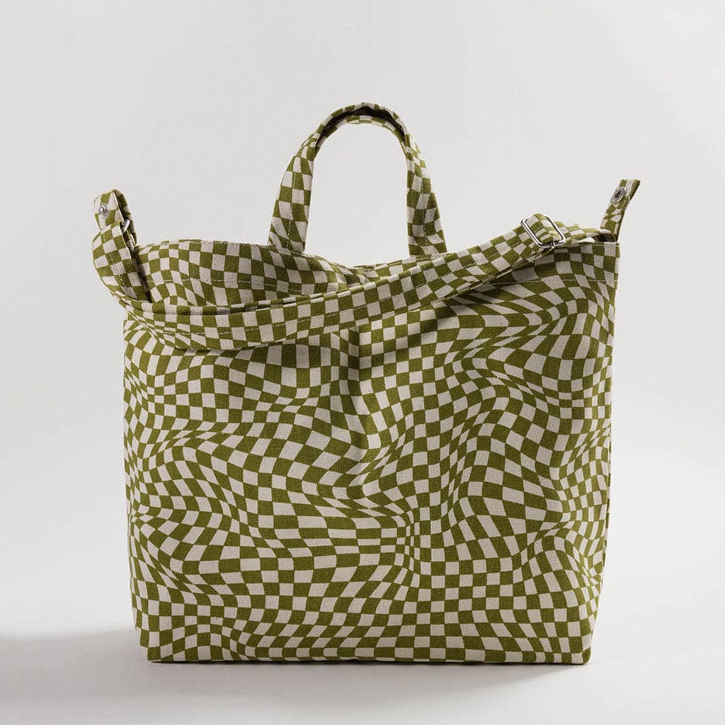 This tote is square shaped and covered in a disoriented, trippy moss and creme checkered pattern. The bag is completed with a pair of small handles and long shoulder strap, both covered in the same pattern. 