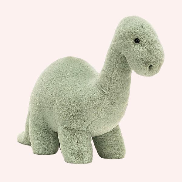 On a white background is a green brontosaurus stuffed animal. 