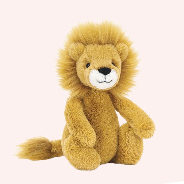 Soft stuffed animal in the shape of a gold lion, with furry made, and soft white muzzle.