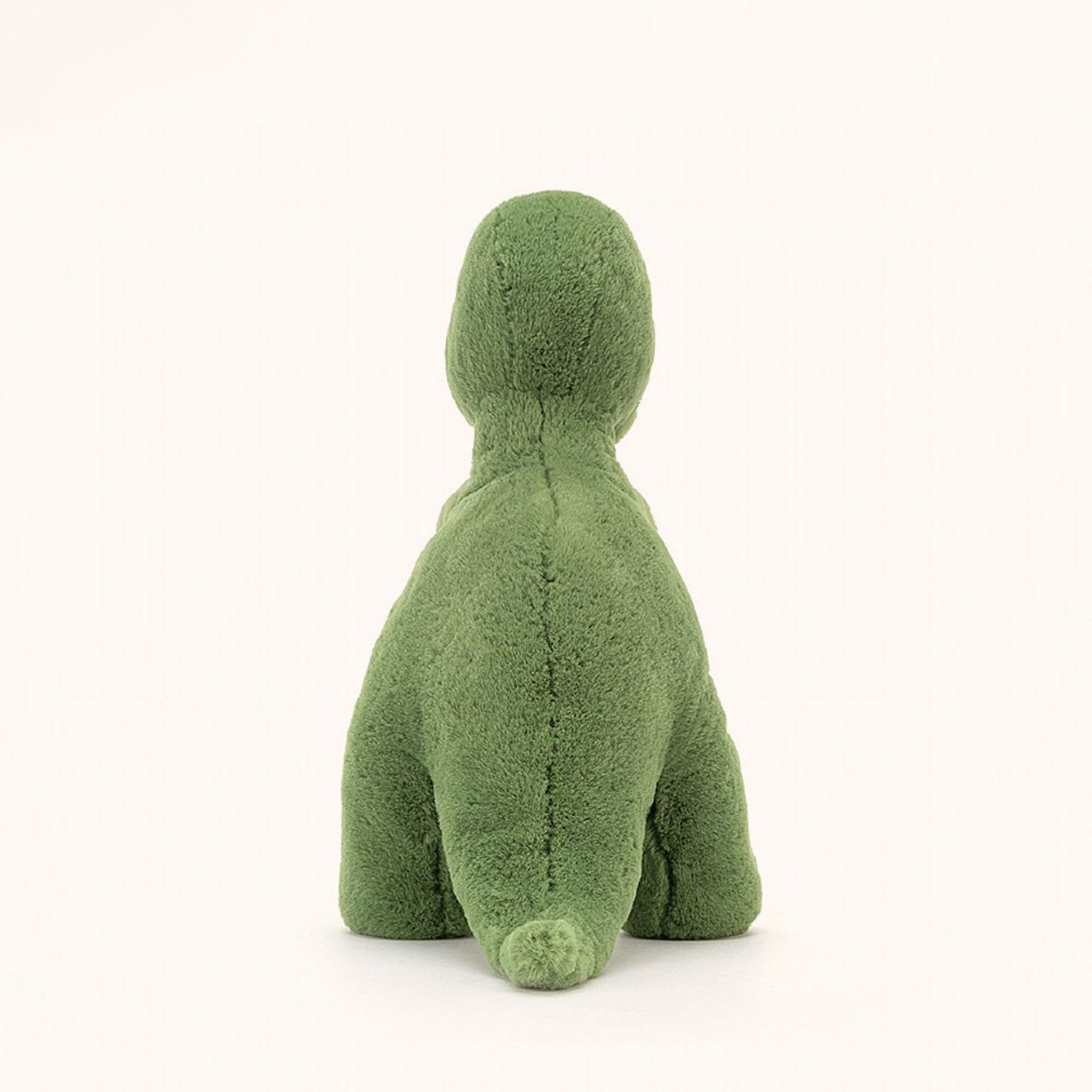 Soft stuffed animal in the shape of a green T-Rex.