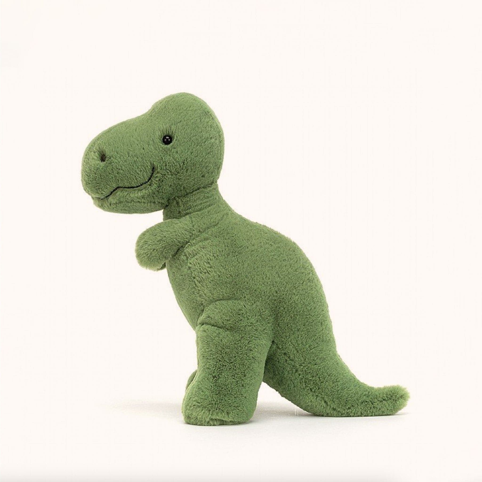 Soft stuffed animal in the shape of a green T-Rex.