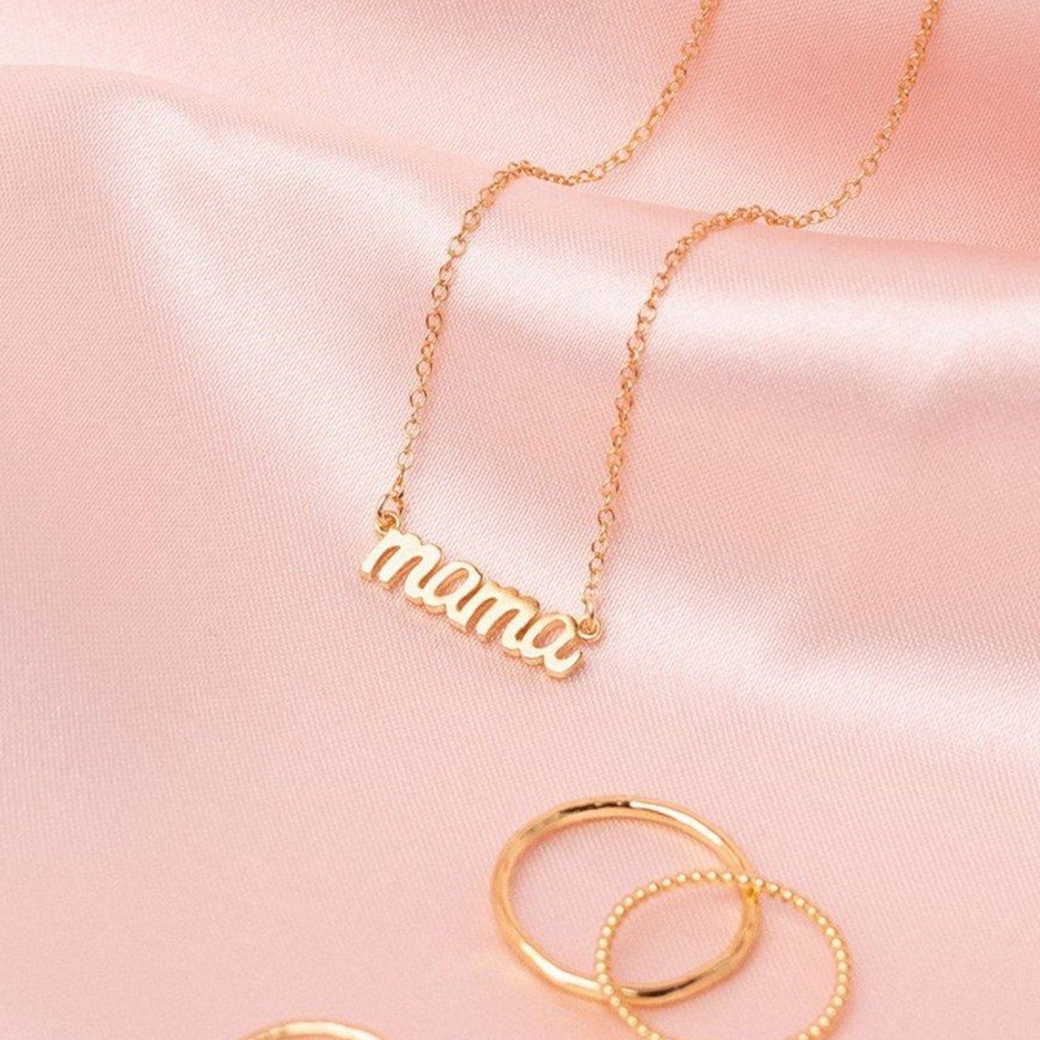 A dainty chain necklace with a small "mama" charm.