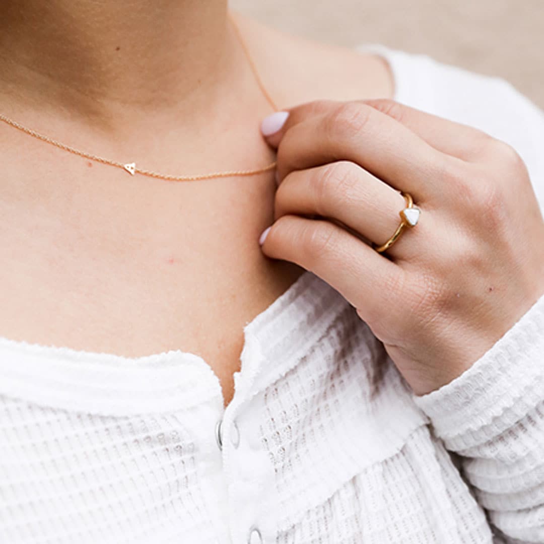 A dainty gold chain necklace with an "A" on the chain. 