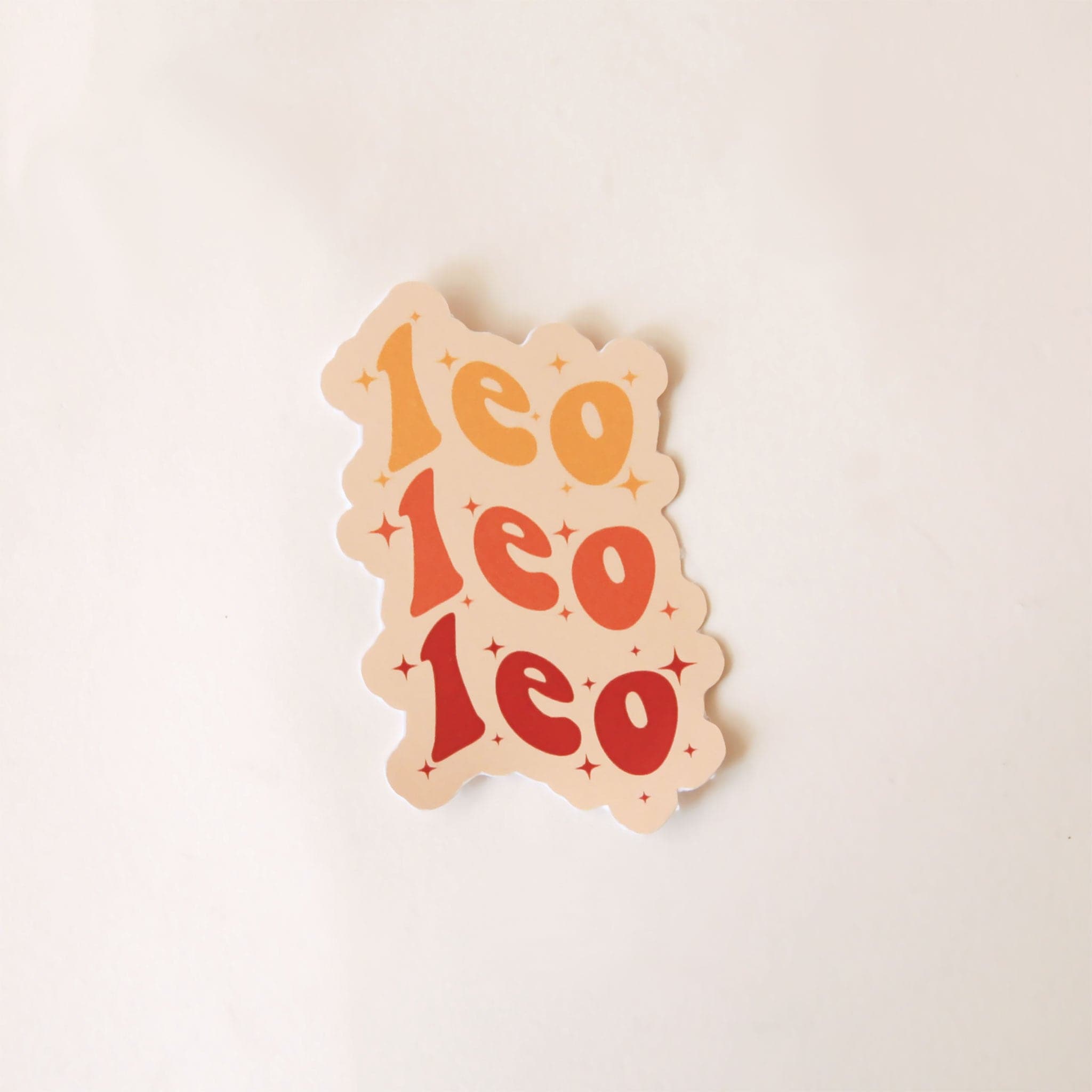 On a white background is a red and yellow sticker with the word &quot;Leo&quot; stacked on top of one another three times in a wavy design. 