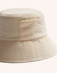 An ivory cotton bucket hat with a ribbed brim and a single side pocket.
