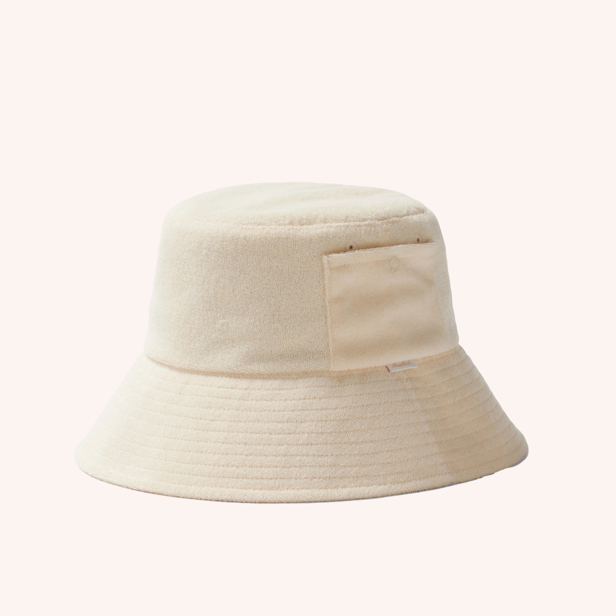 An ivory cotton bucket hat with a ribbed brim and a single side pocket.