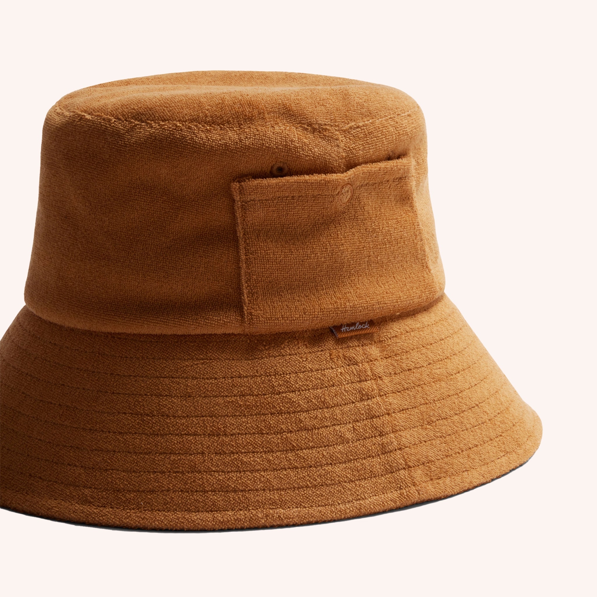 A cotton bucket hat in a dark yellow shade with a ribbed brim and a small side pocket.
