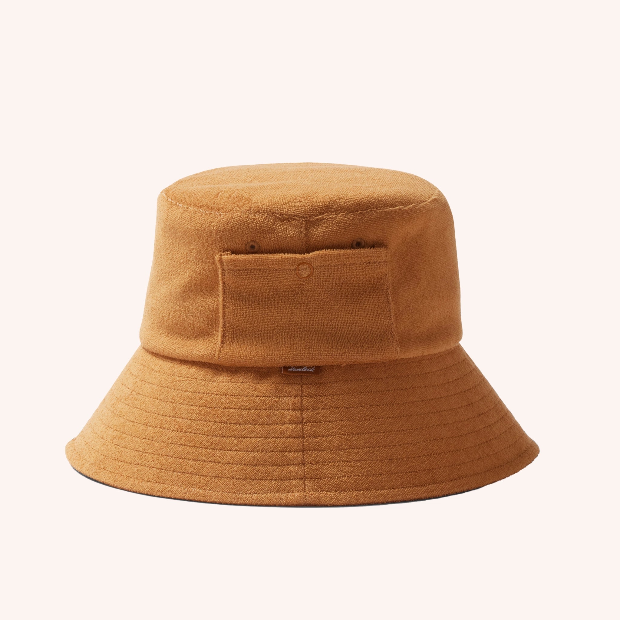 A cotton bucket hat in a dark yellow shade with a ribbed brim and a small side pocket.
