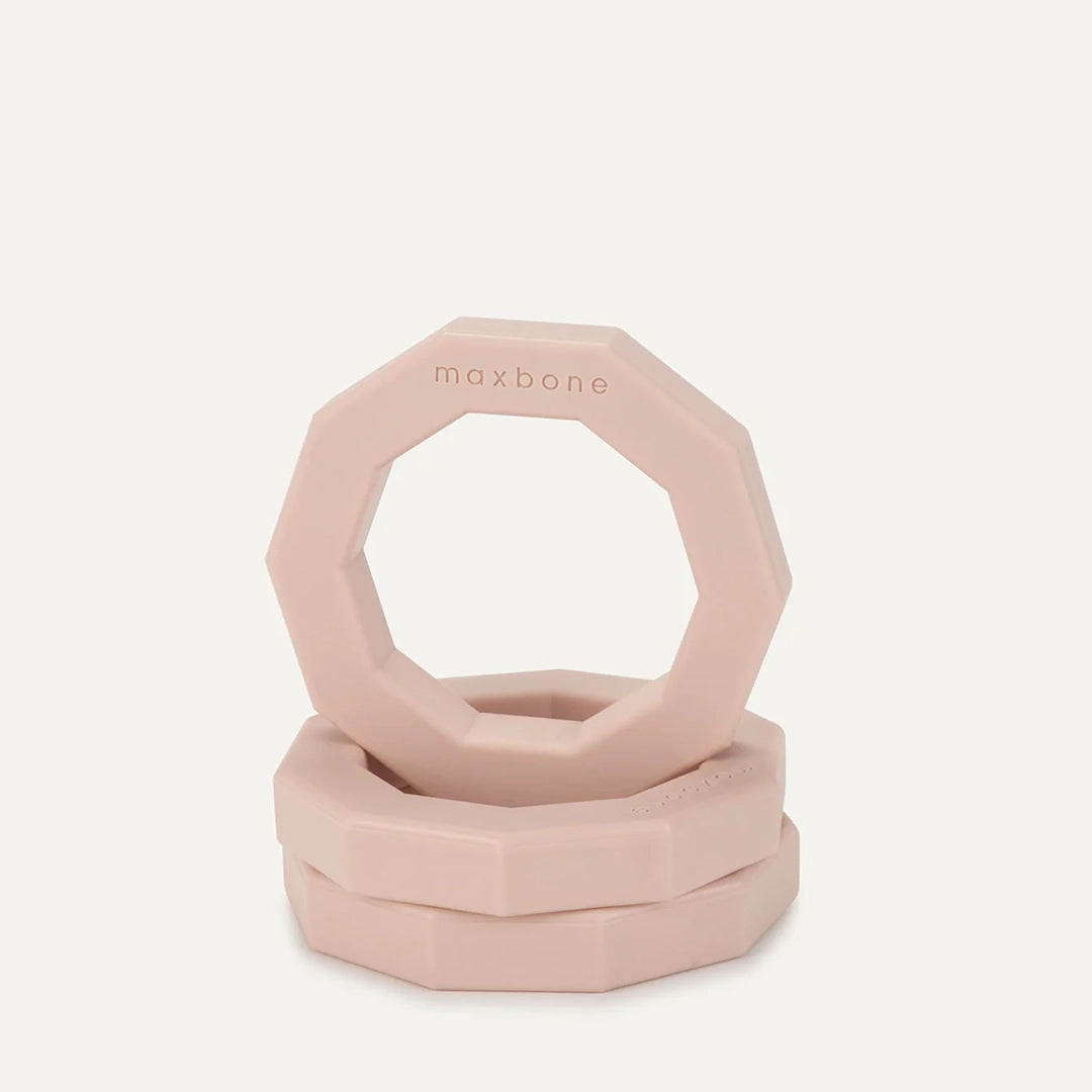 A decagon ring shaped rubber dog toy in light peachy color.