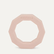 A decagon ring shaped rubber dog toy in light peachy color.