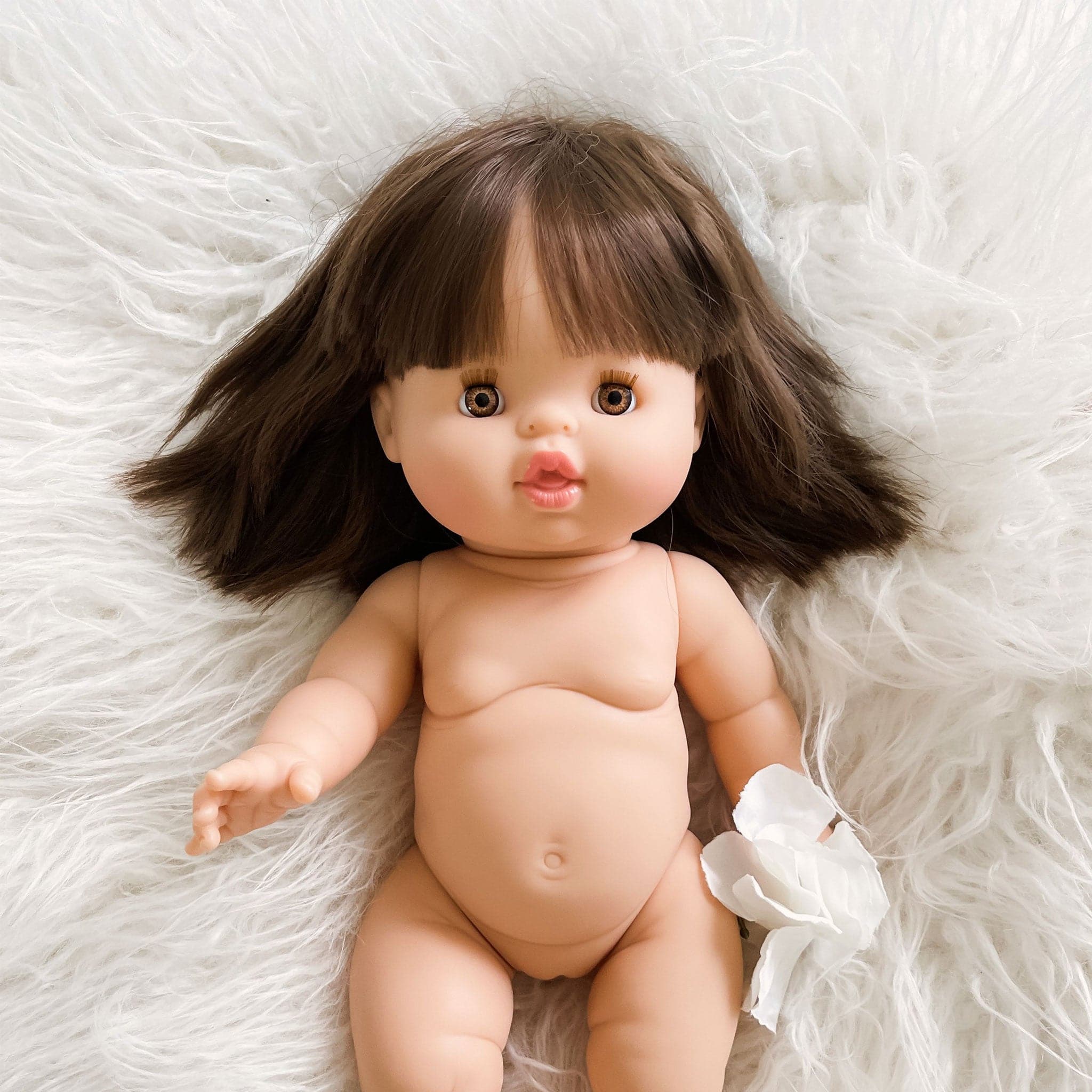 A baby doll with brown straight hair and amber colored eyes. 
