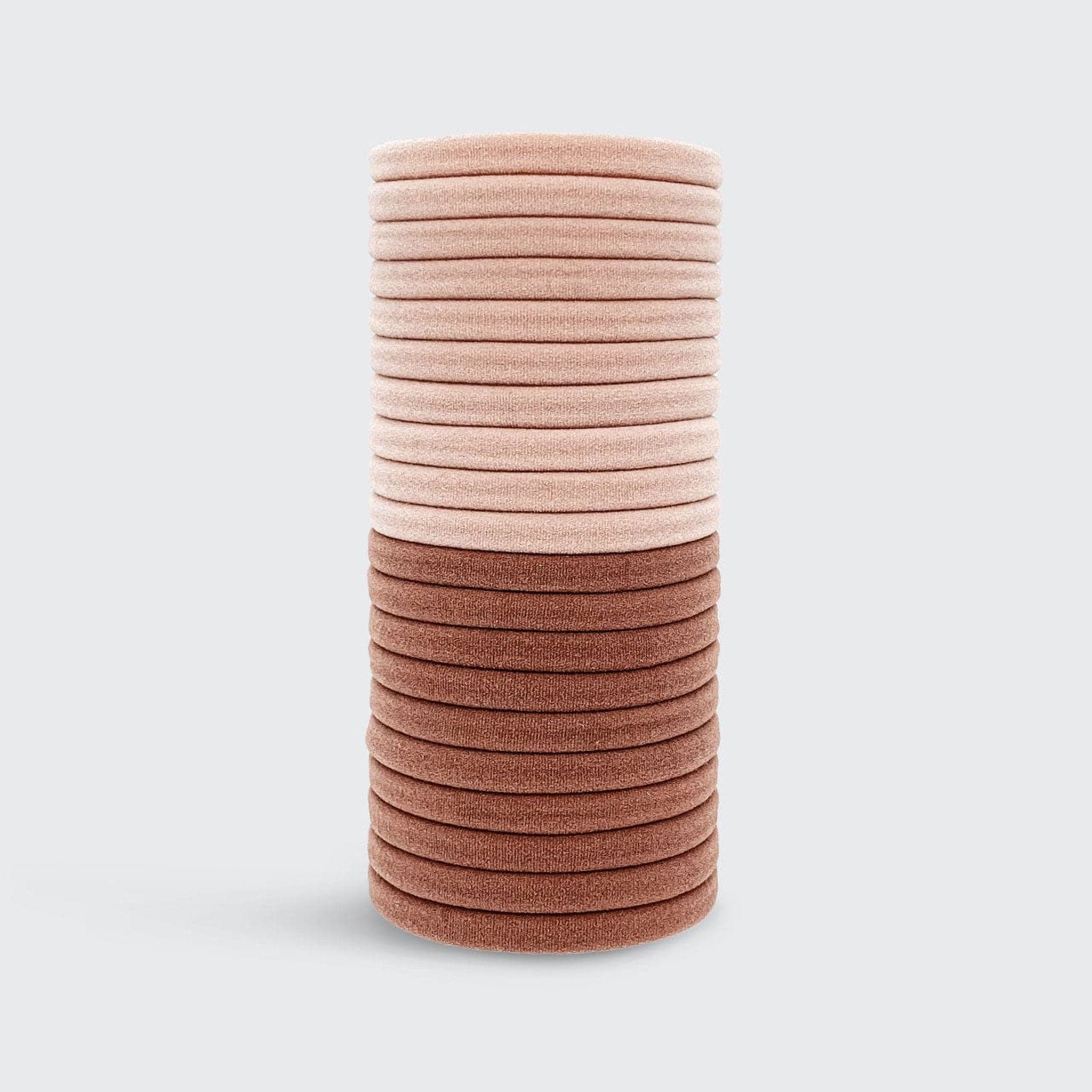 A stack of round recycled nylon elastic hair ties in a light pink shade and a slightly darker blush pink shade. 