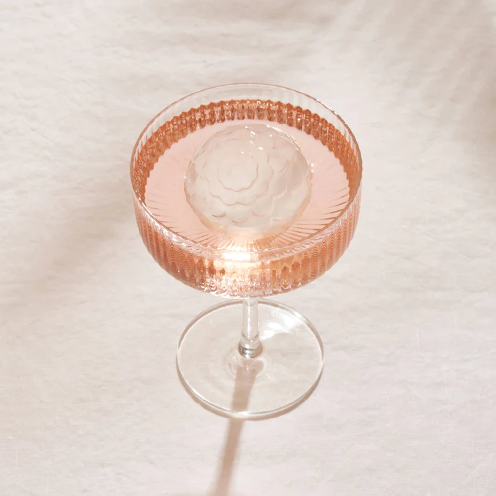 A cocktail glass with a petal ribbed detailing in a sphere shape.