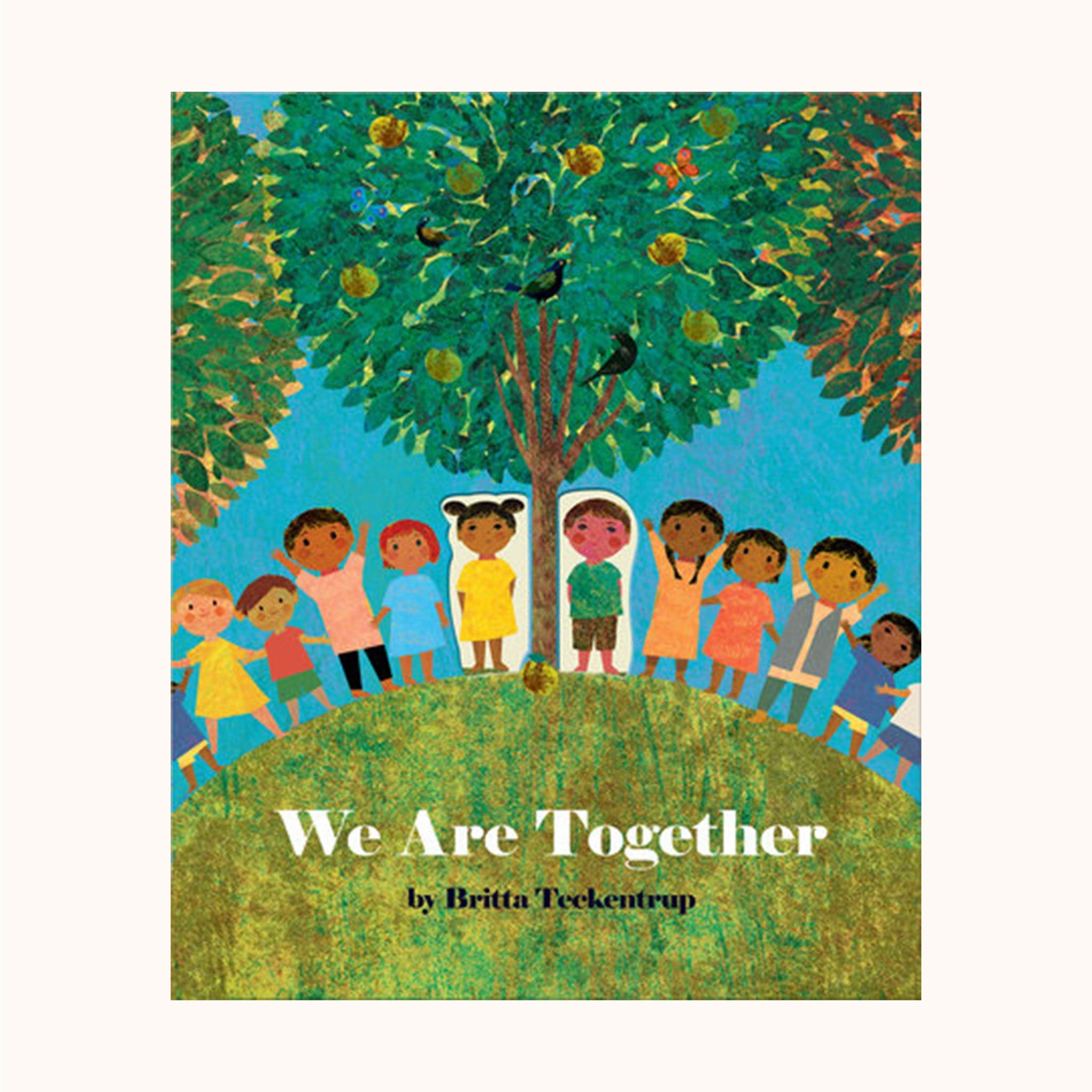 This children&#39;s picture book cover features a row of lively children standing side by side below three towering trees. The tree in the middle is in focus and the other two peak into the frame. The title reads &#39;We Are Together&#39; in white text over the textured green, round hill the children stand on. 