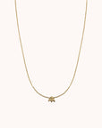 A super dainty gold chain necklace with a tiny bee pendant in the center.