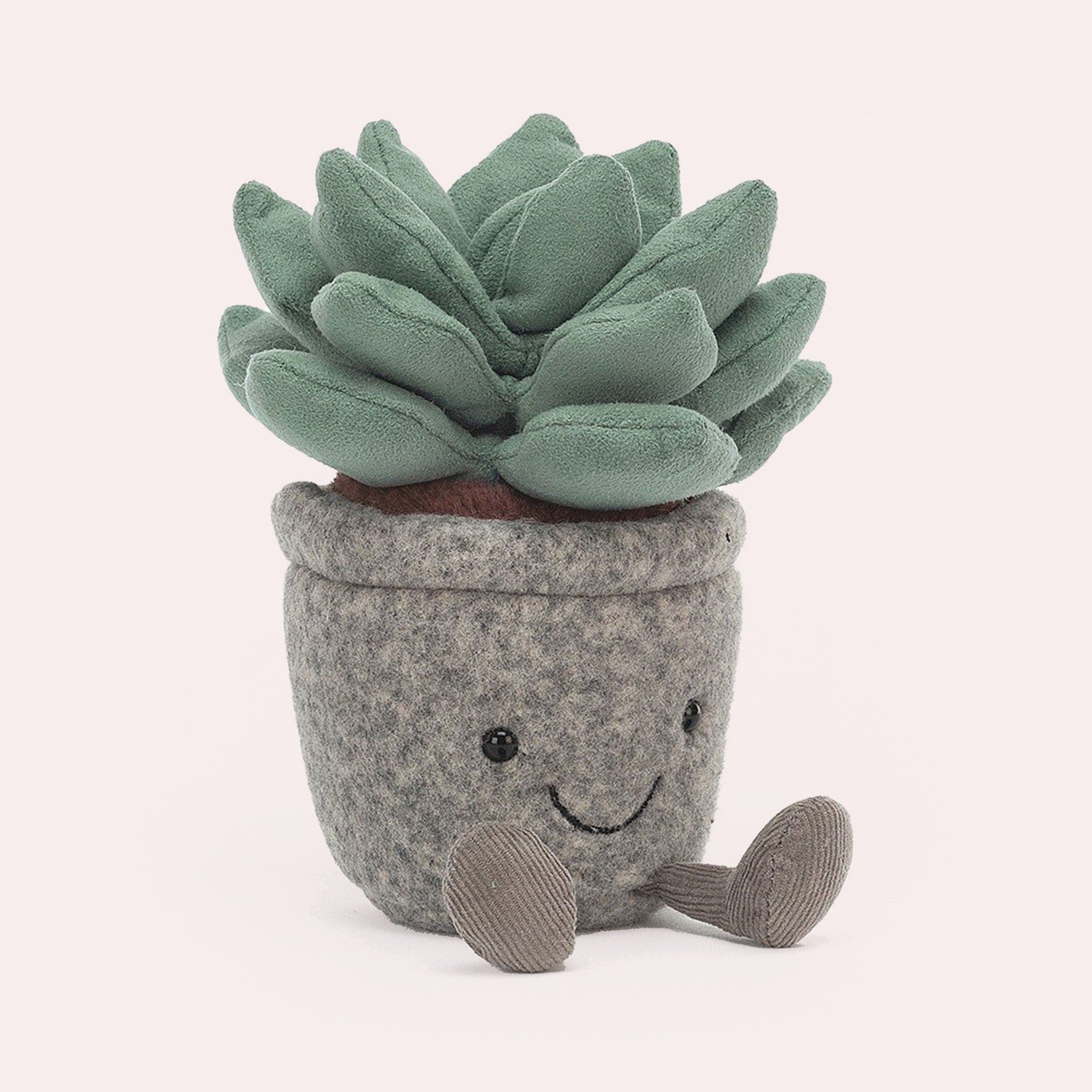 A stuffed toy succulent with little legs and a happy smiley face.