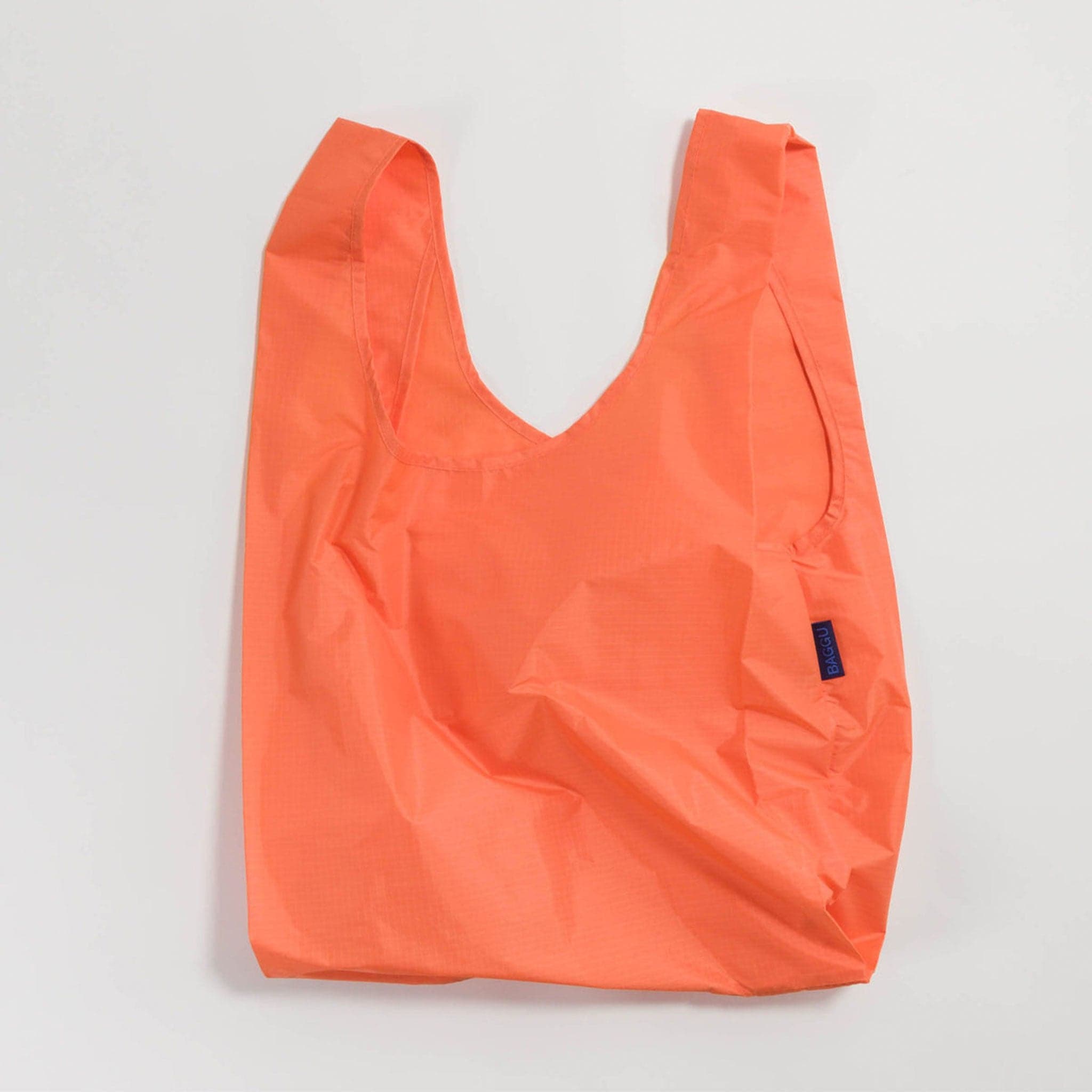 A neon salmon colored reusable bag.