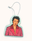Light aqua air freshener with display the top half of Harry Styles wearing an iconic pink polo dot suit and cross necklace. A white elastic loop is fastened above ready to be hung. 
