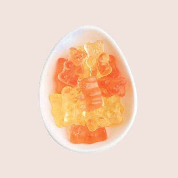 The champagne bears that are light pink and a champagne colored photographed in a bowl. 