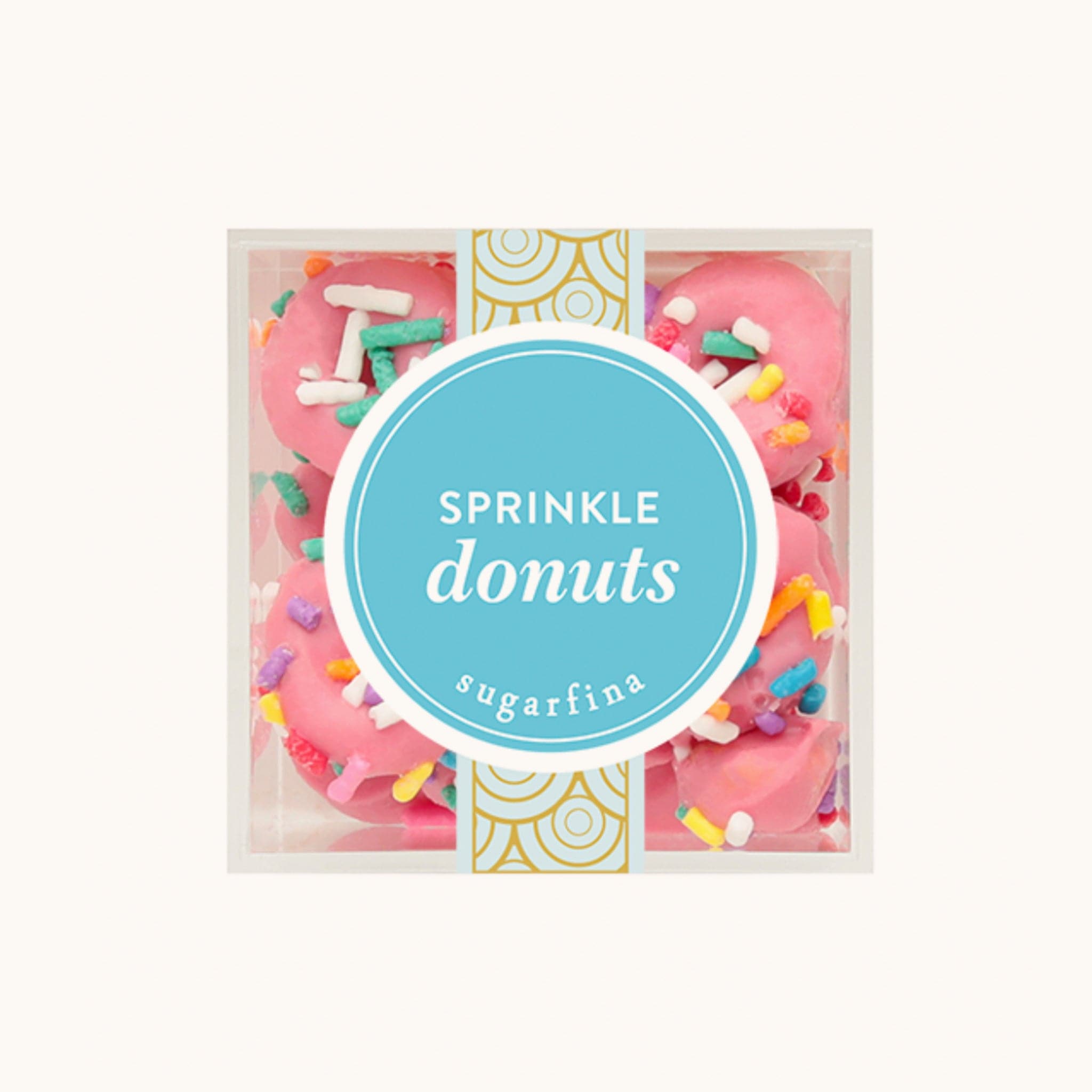 Plastic cube of miniature pink donut candies topped with colorful sprinkles. The box reads 'Sprinkle donuts' across a teal circular logo. 