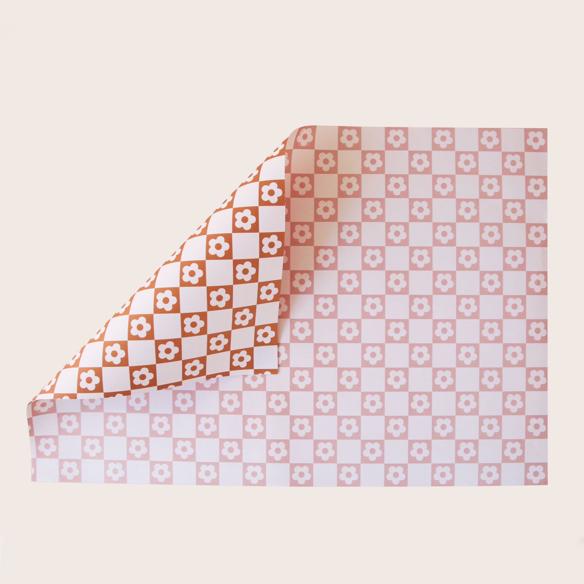 A rust and light pink daisy patterned wrapping paper. 