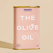 A pink tin of olive oil with gold accents on the top and bottom along with white text that reads, "The Olive Oil".