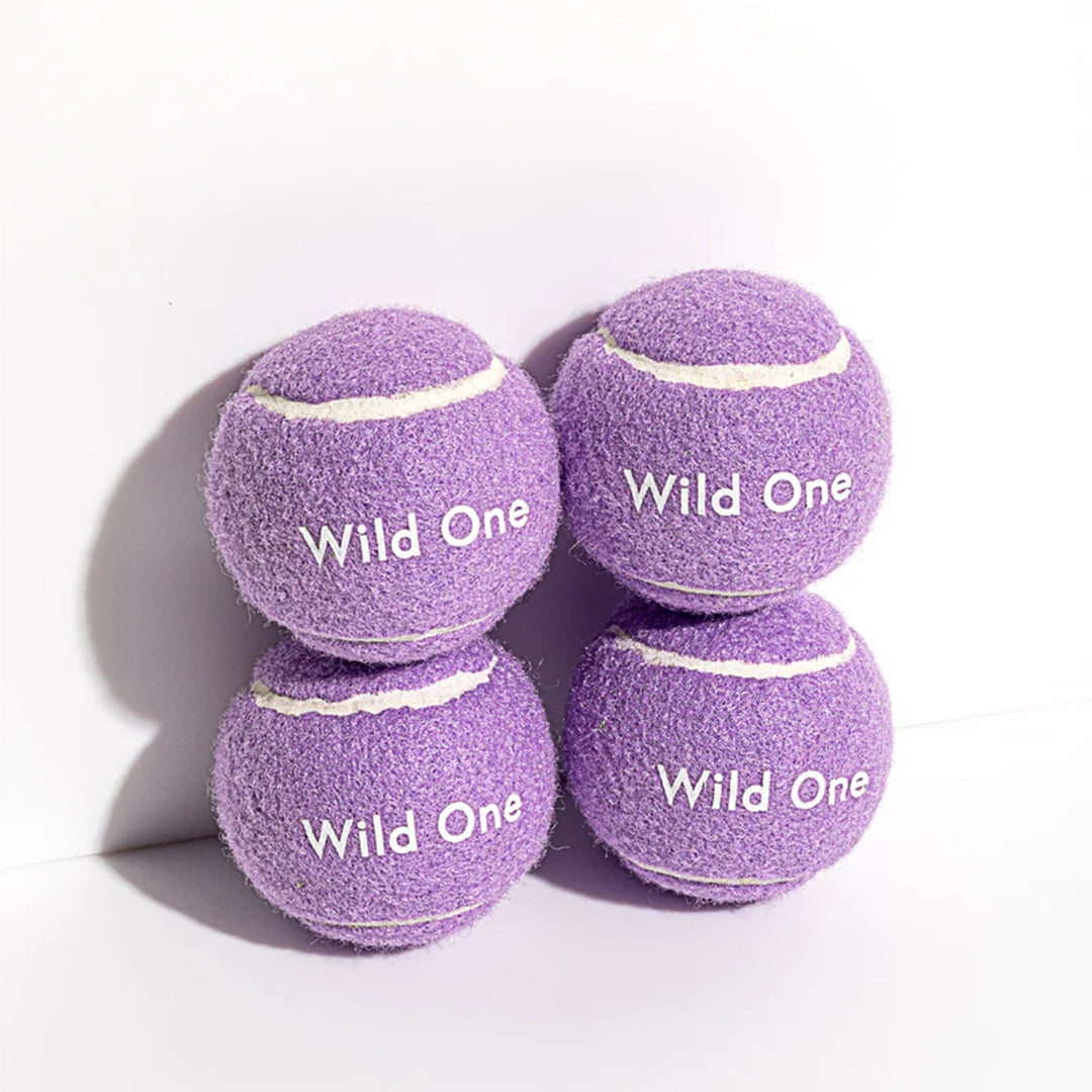 Purple tennis balls that read, "Wild One" in white text.