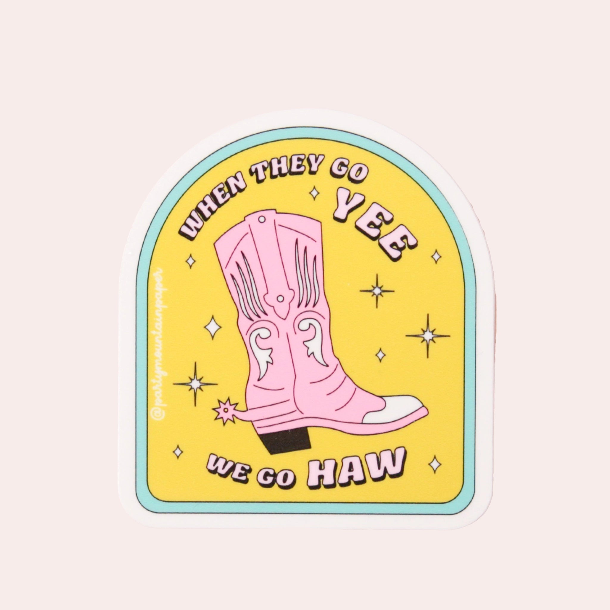 A yellow arched sticker with a light blue rim and a pink cowgirl boot in the center along with pink text that reads, "When They Go Yee We Go Haw".
